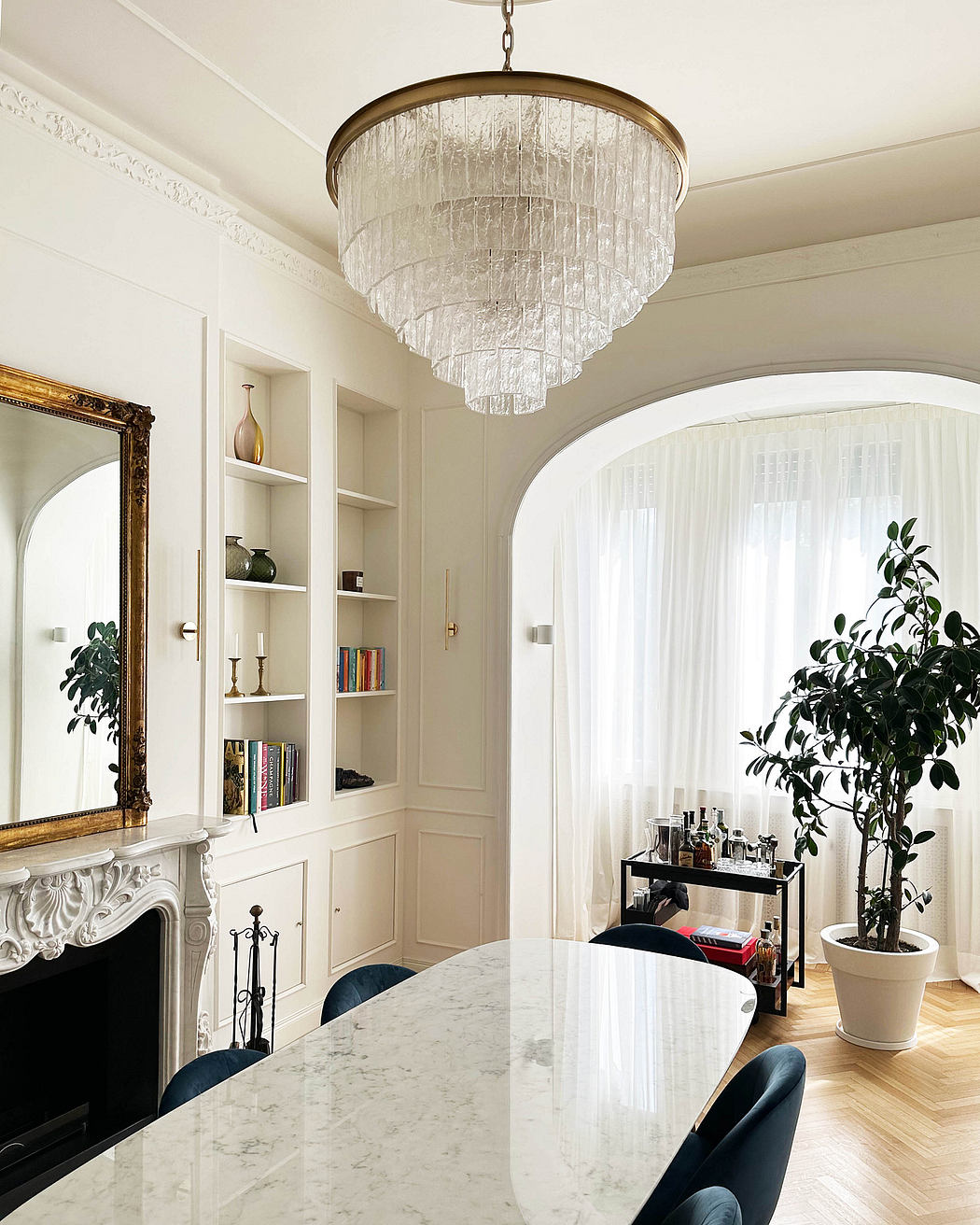 Elegant dining room with crystal chandelier and white decor.