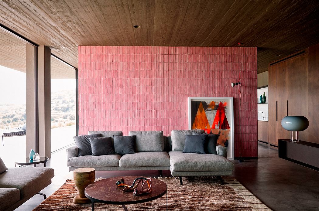 Modern living room with a red feature wall, gray sectional sofa, and wooden accents