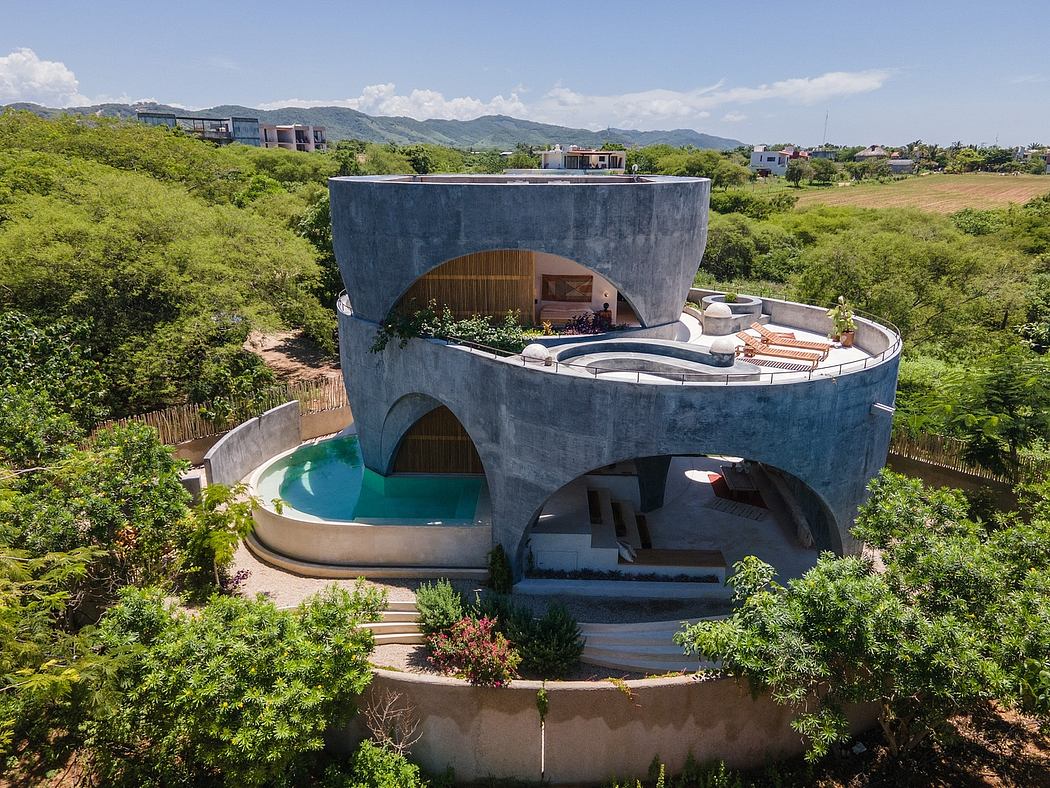 Circular concrete structure with wood accents, pool, and terraced exterior surroundings.