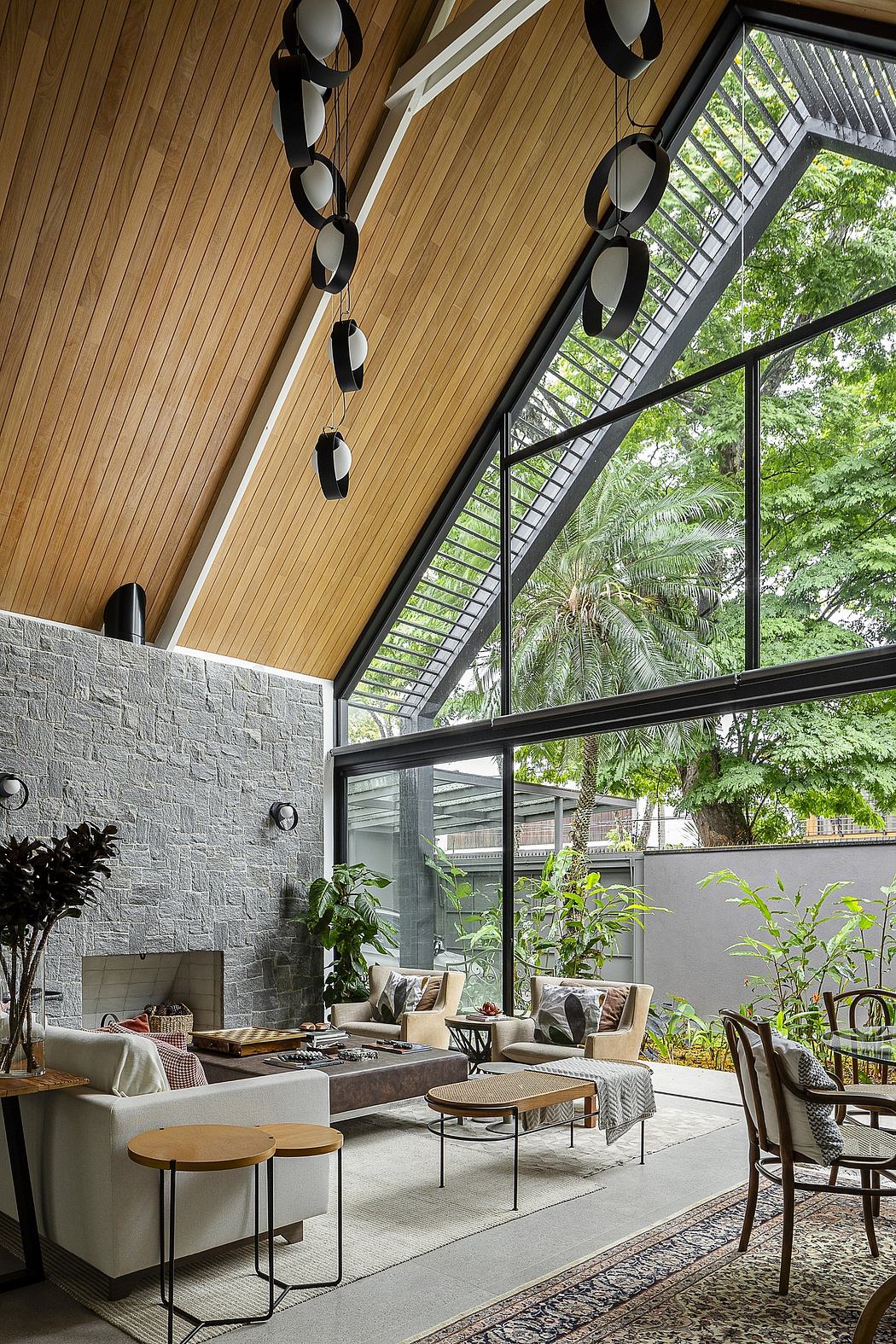 Sleek living space with high ceiling, glass walls, and wooden beams,