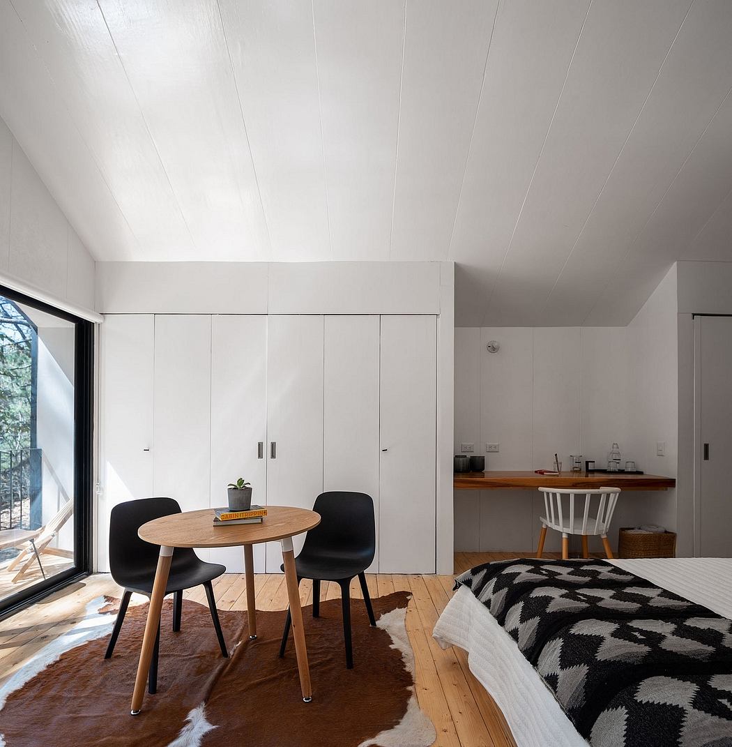 Modern, minimalist interior with wooden furniture, built-in storage, and large windows.