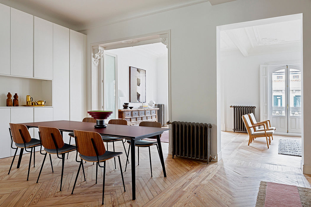 Bright, spacious room with a dining table, chairs, and elegant wooden flooring.