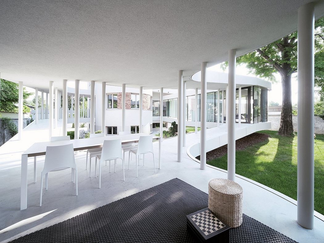 A bright, modern, and open interior with clean lines, large windows, and a lush green outdoor view.