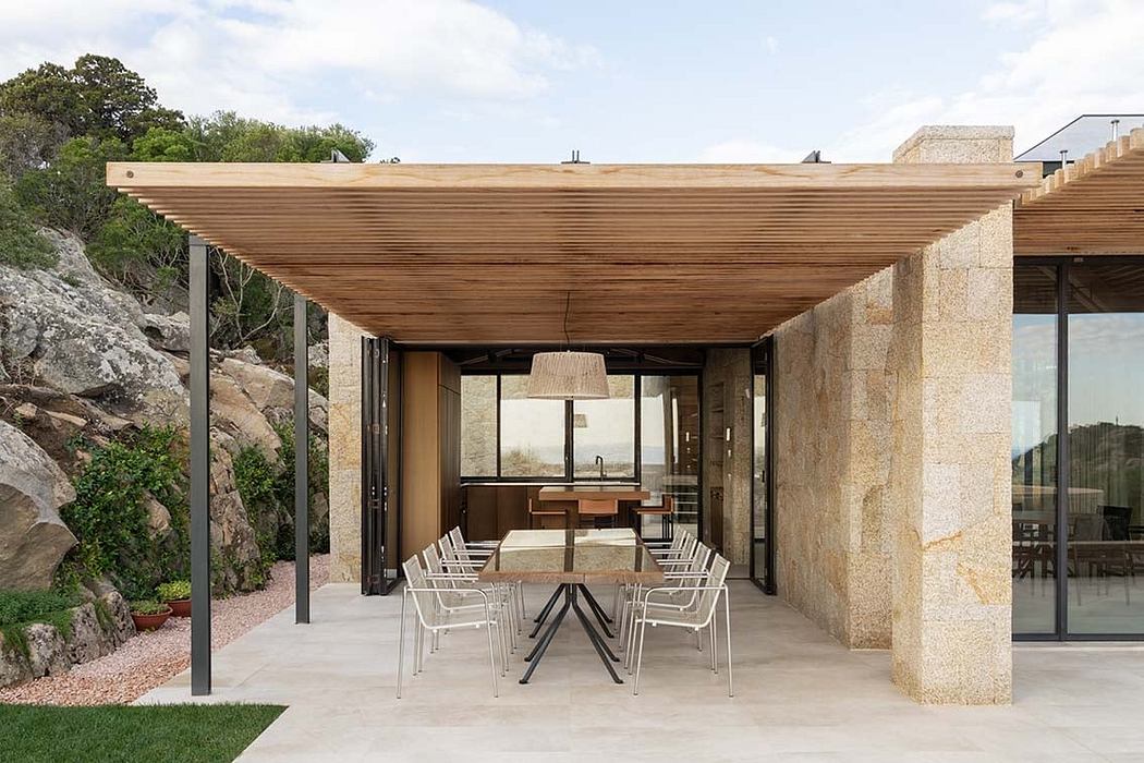Modern patio with wooden pergola, stone walls, and outdoor dining set.