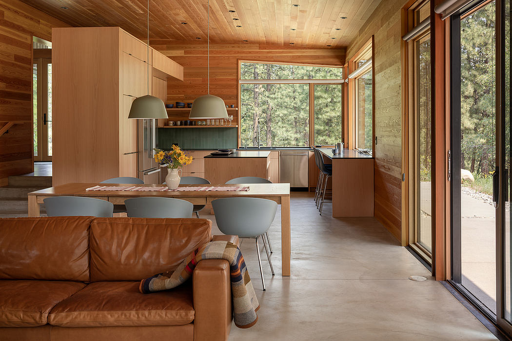 Wood-clad interior with large windows and cozy furnishings.