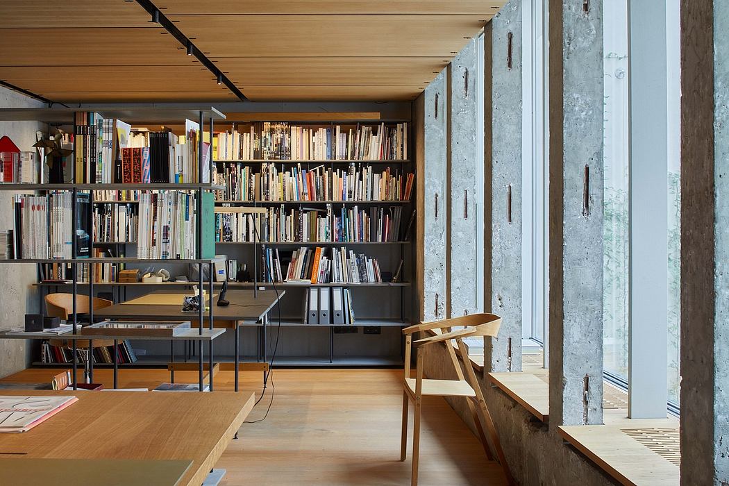 Minimalist industrial-style library with concrete, wood, and steel elements.