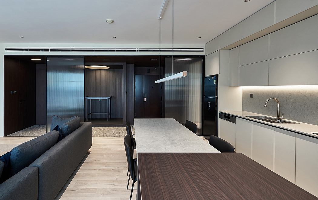 Sleek modern space with minimalist kitchen, dining table, and living area.