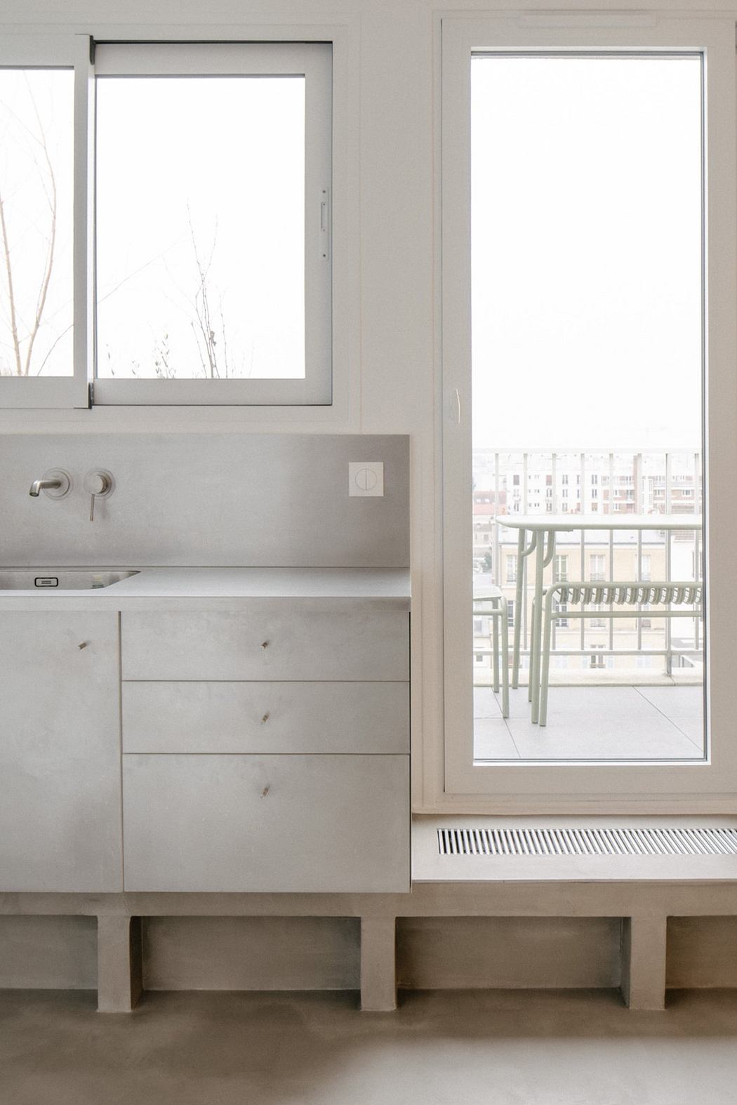 Minimalist bathroom vanity with sleek cabinetry next to a tall window.