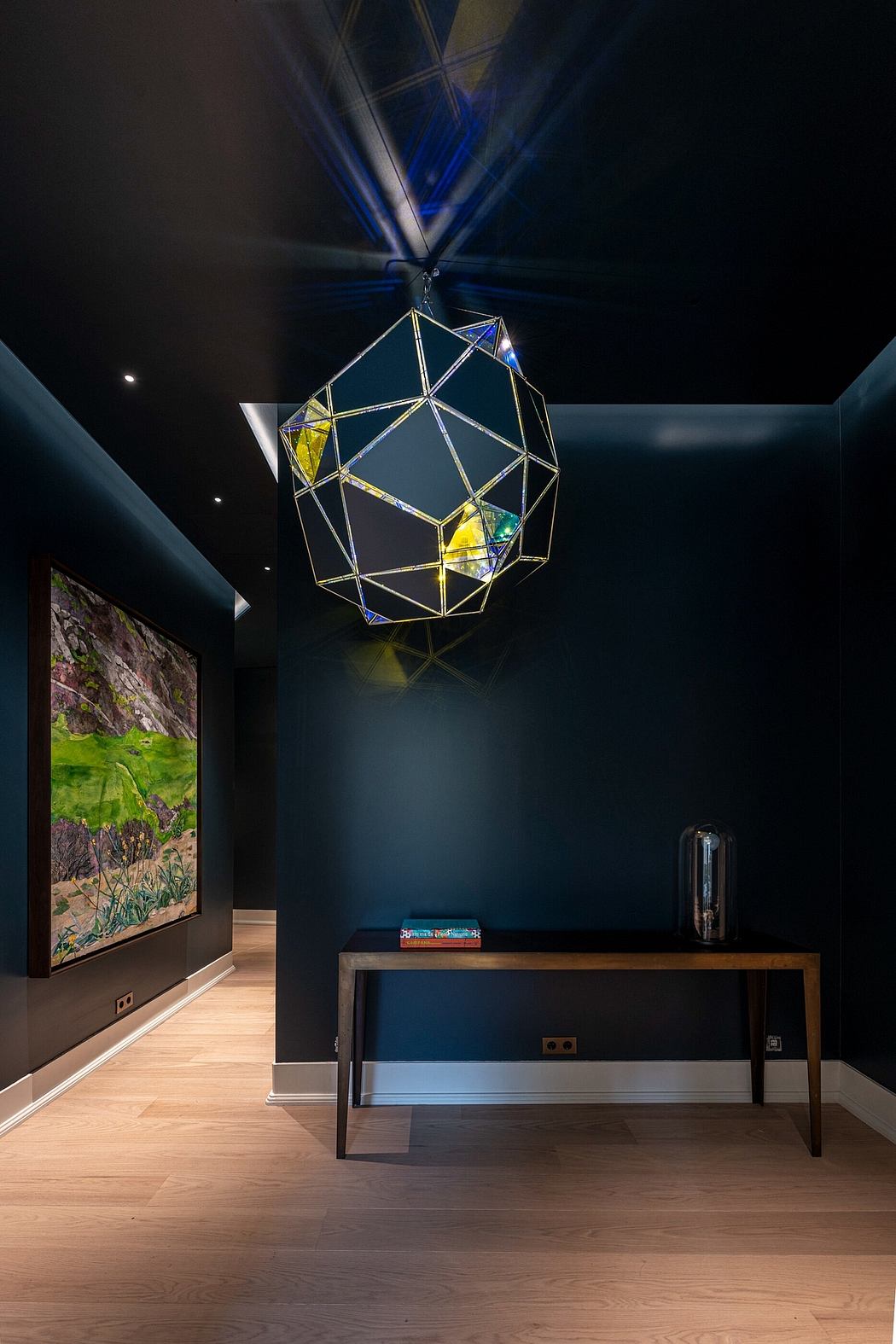 Contemporary hallway with geometric pendant light and dark walls.