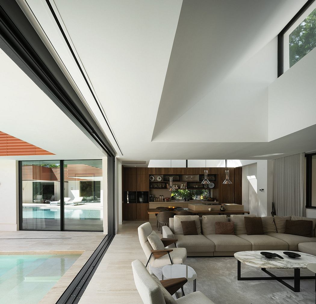 Minimalist open-concept living area with sleek kitchen, large windows, and outdoor pool.