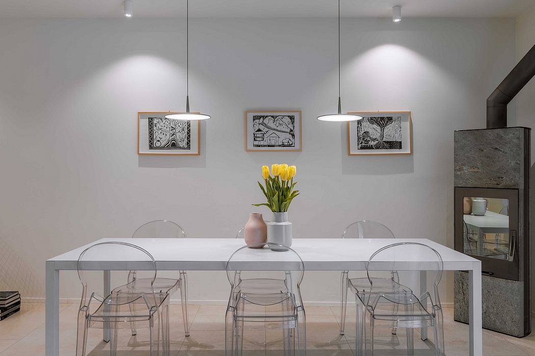 Minimalist dining area with a clear glass table, transparent chairs, and pendant lights