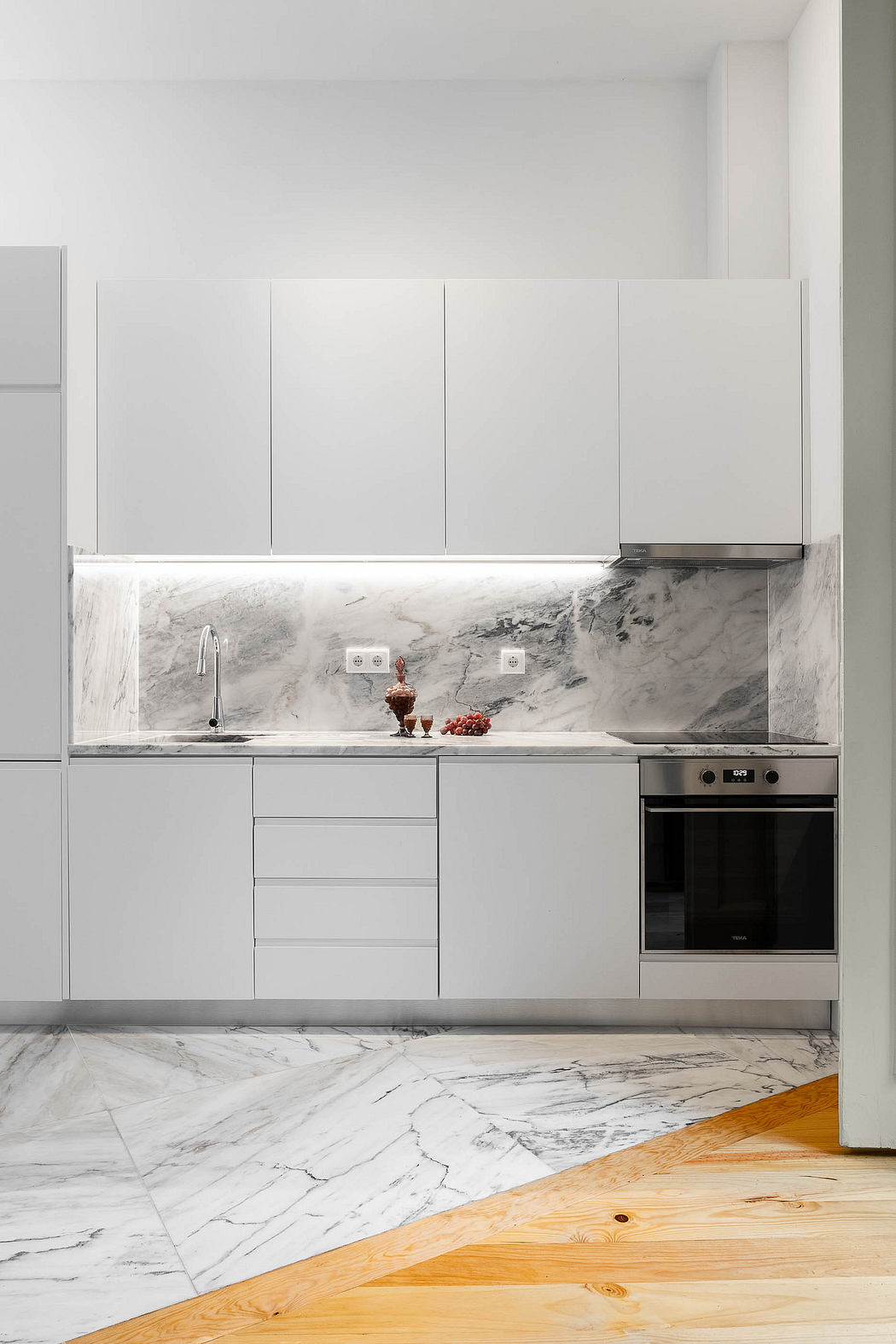 Modern kitchen with marble backsplash and gray cabinets