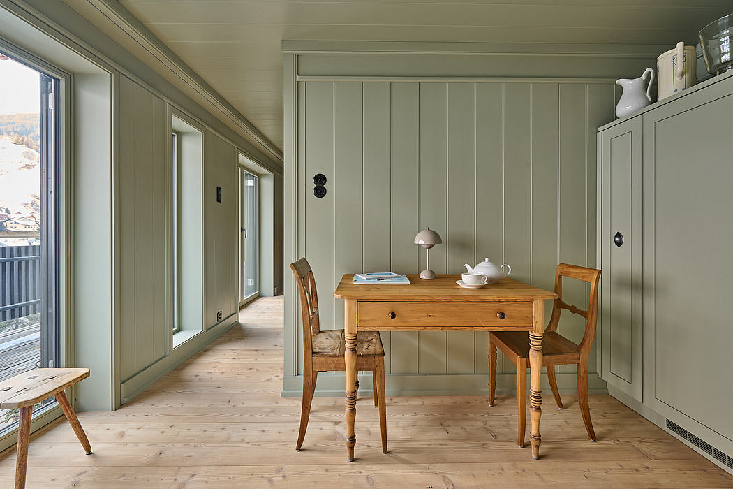 Scandinavian-style interior with a wooden table, chairs, and pale green walls