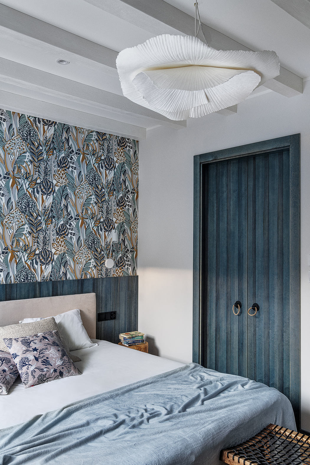 Modern bedroom with patterned wallpaper and decorative ceiling light.