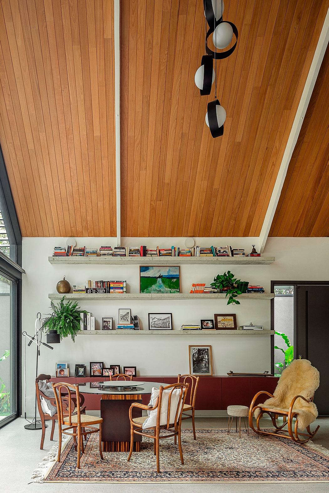 Contemporary dining room with slanted wooden ceiling and eclectic decor.