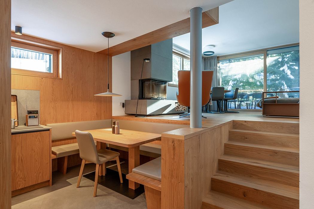 Cozy dining area with wooden walls, open floor plan, and view of snowy outdoor scenery.