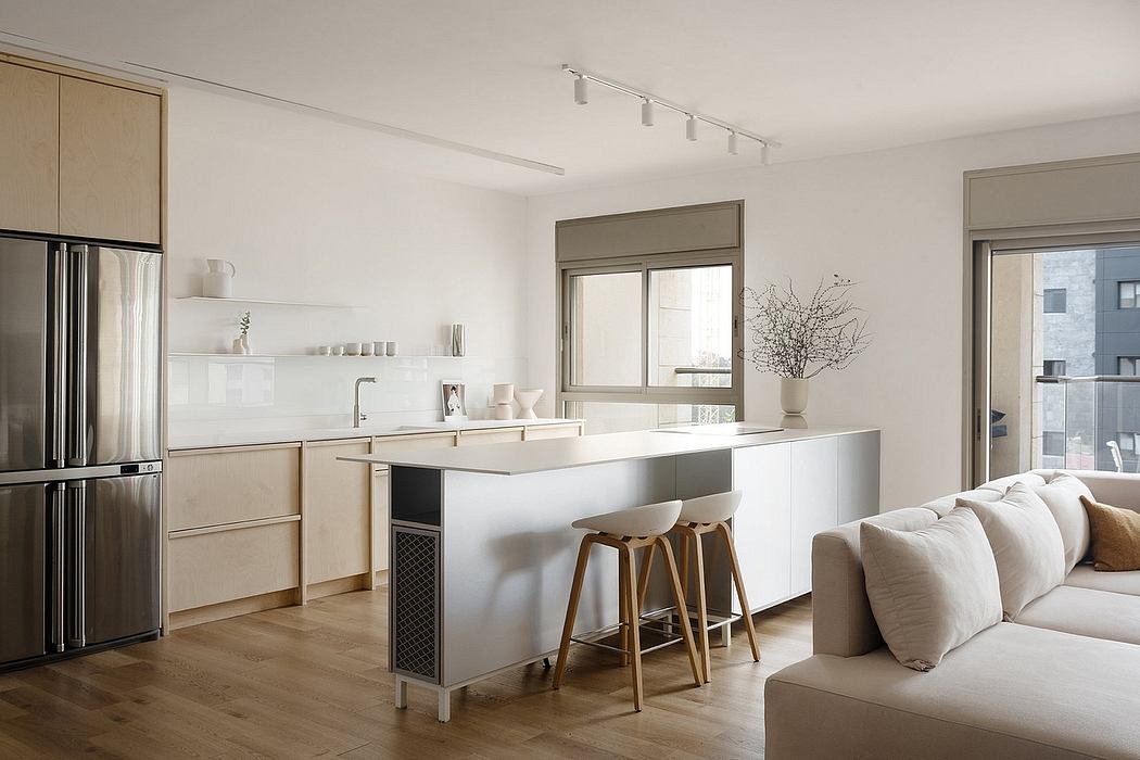 Modern kitchen and living area with neutral tones and natural light.