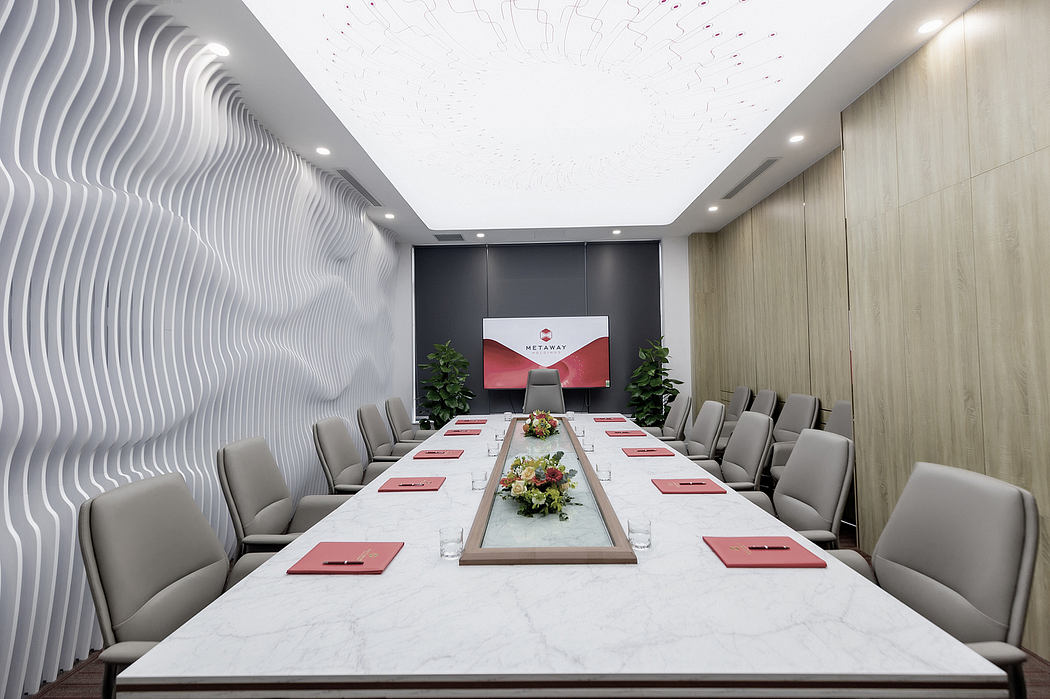 Sleek, modern conference room with undulating wall panels, marble table, and floral centerpiece.
