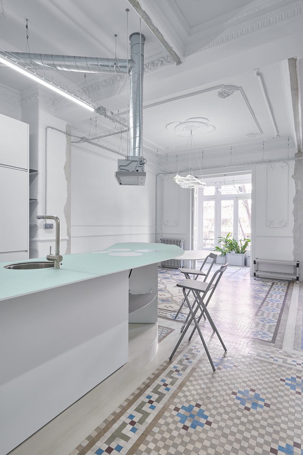 A beautifully renovated kitchen with ornate ceiling and patterned tile flooring.
