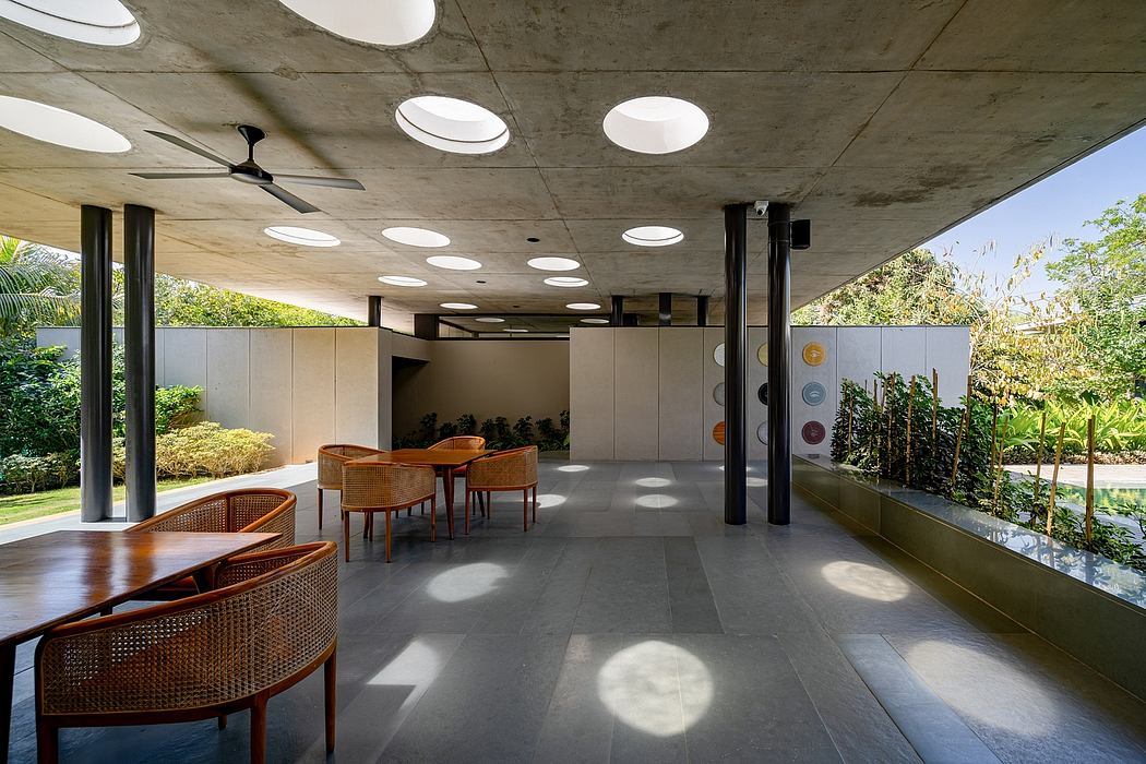 Striking concrete ceiling with recessed lighting, modern furnishings, and lush outdoor views.