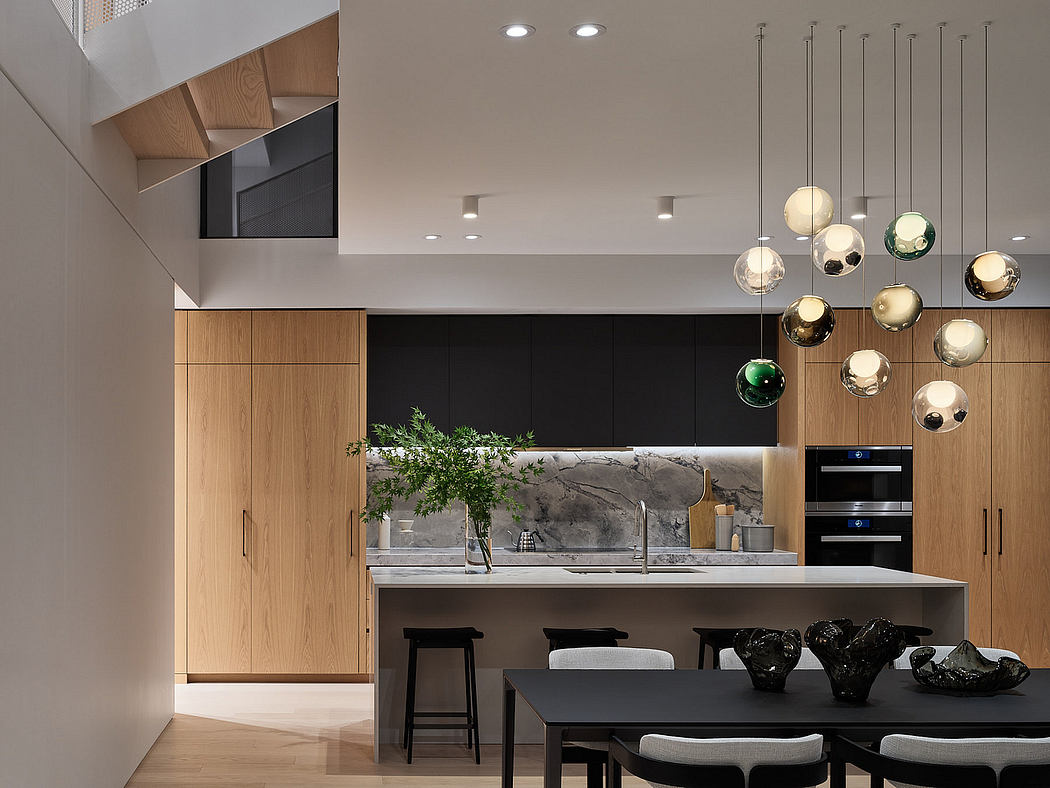 Elegant kitchen with wood cabinetry, marble backsplash, and designer globe lighting