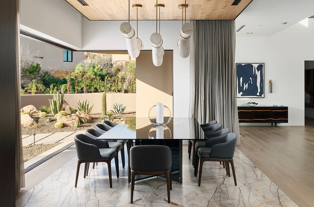 Sleek dining room with chandelier, marble floor, and modern furniture overlooking lush garden.