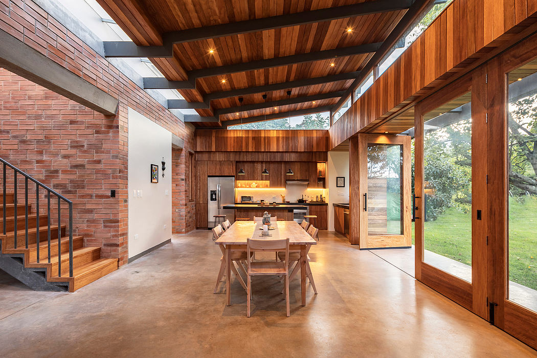 Expansive interior with wooden beams, brick walls, and open kitchen-dining area.