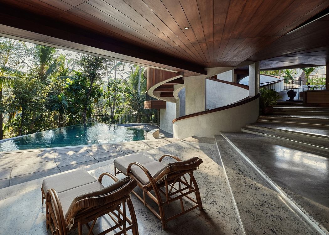 Modern tropical villa with wooden ceilings, concrete steps, and inviting pool area.