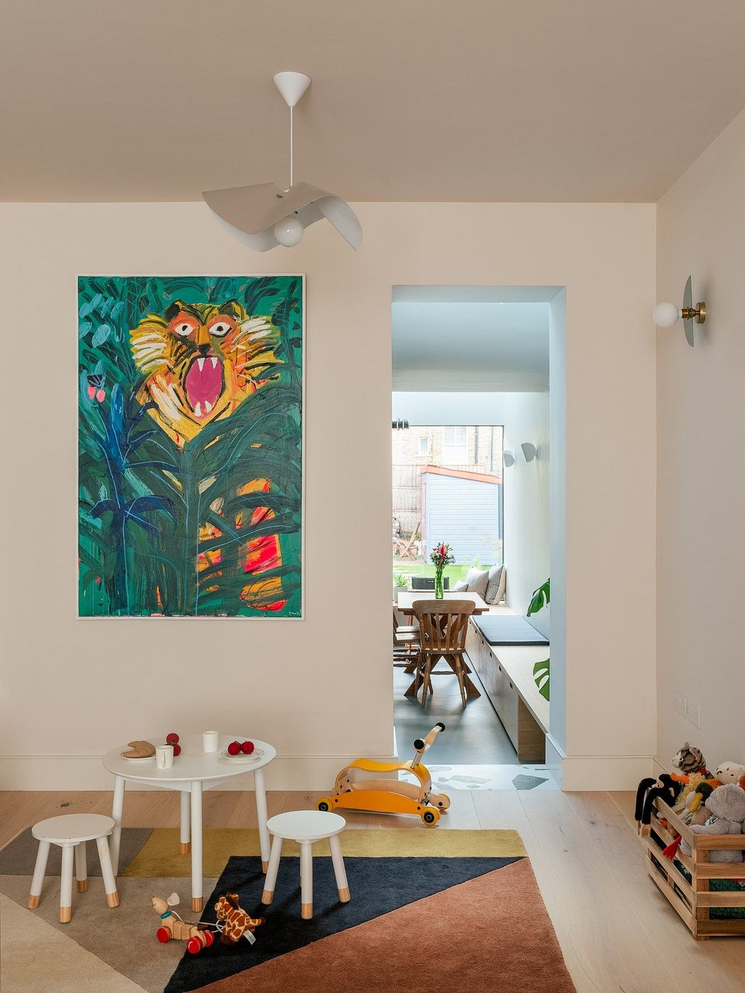 Bright room with a colorful painting, children's table, toys, and a view