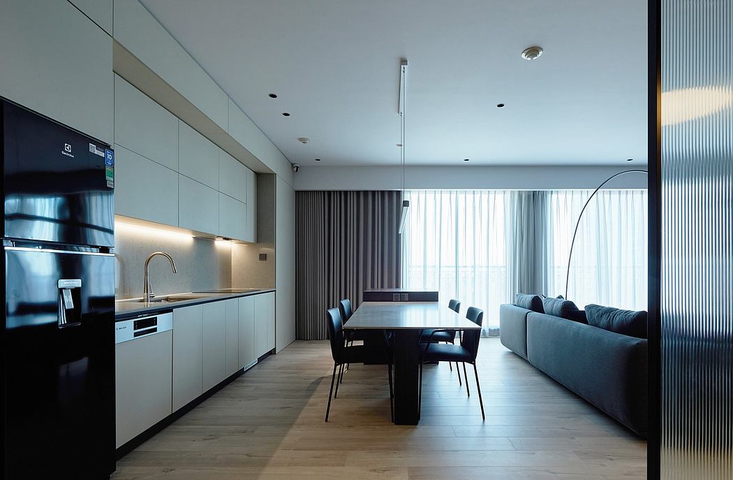 A modern, minimalist kitchen and dining area with sleek cabinetry and large windows.