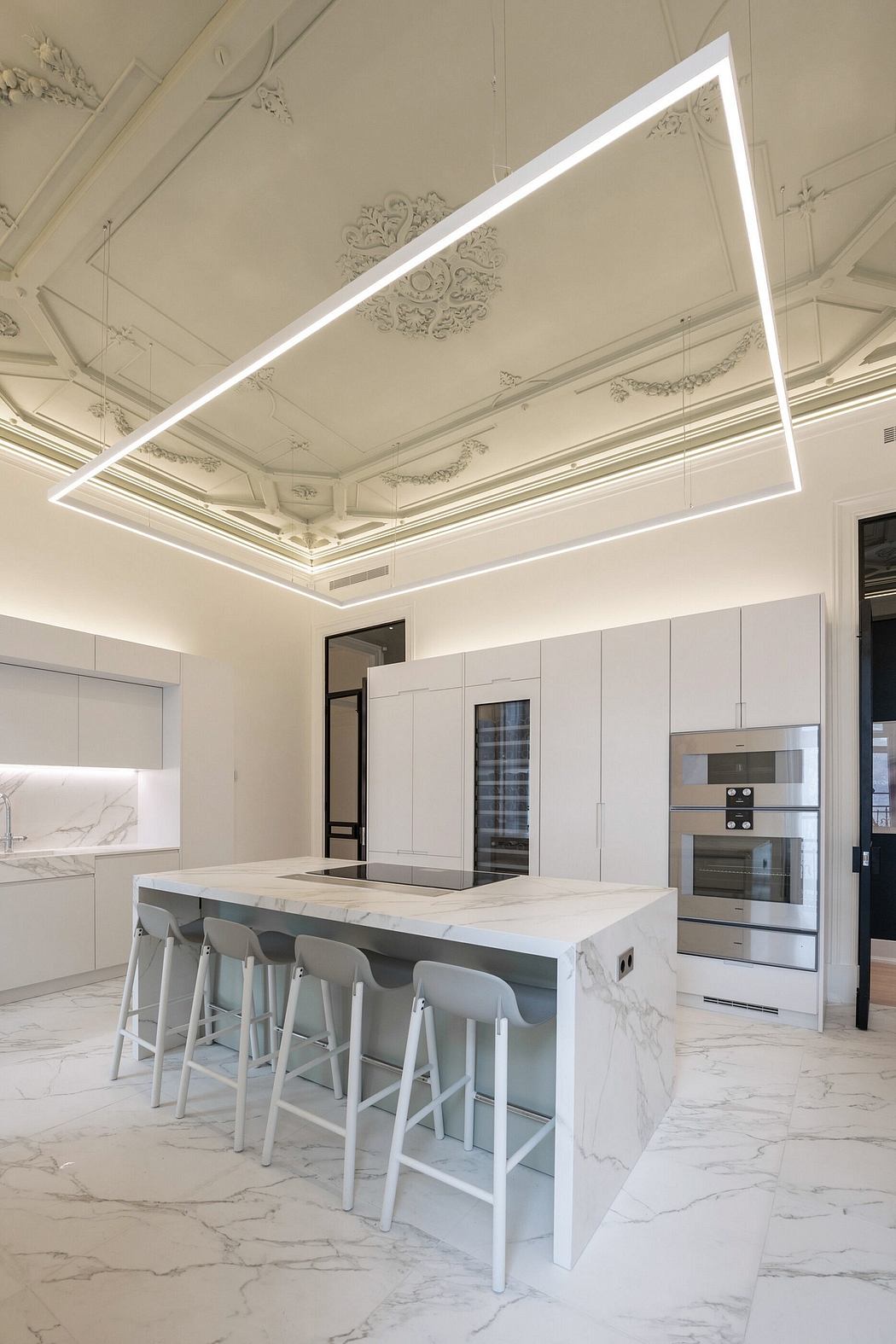 Modern kitchen interior with LED ceiling lights and marble island.