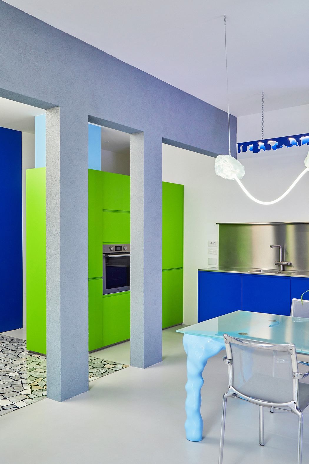 Vibrant colors, geometric shapes, and modern appliances create a playful kitchen design.