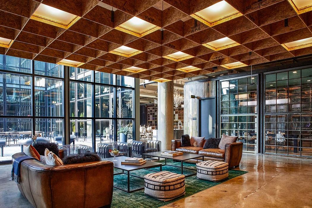 Luxurious, industrial-style lobby with a grid of recessed lighting, exposed beams, and modern furnishings.