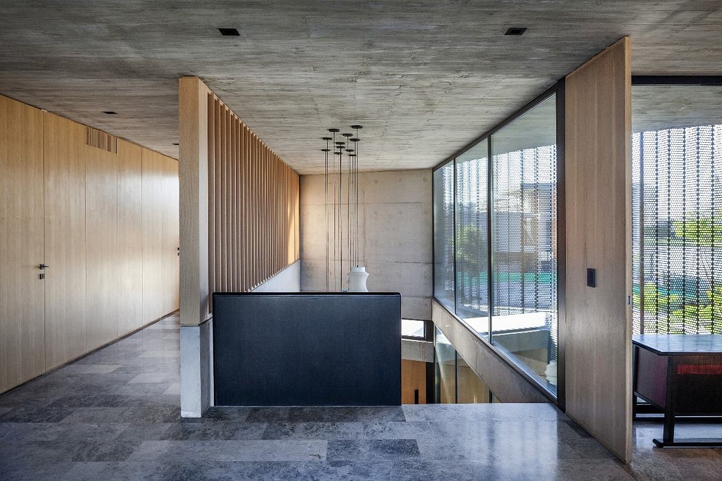 Minimalist interior featuring concrete, wood paneling, and glass walls.