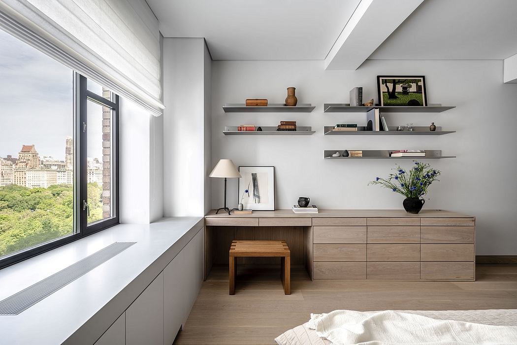 Spacious, modern room with wood furniture, built-in shelving, and expansive window overlooking nature.