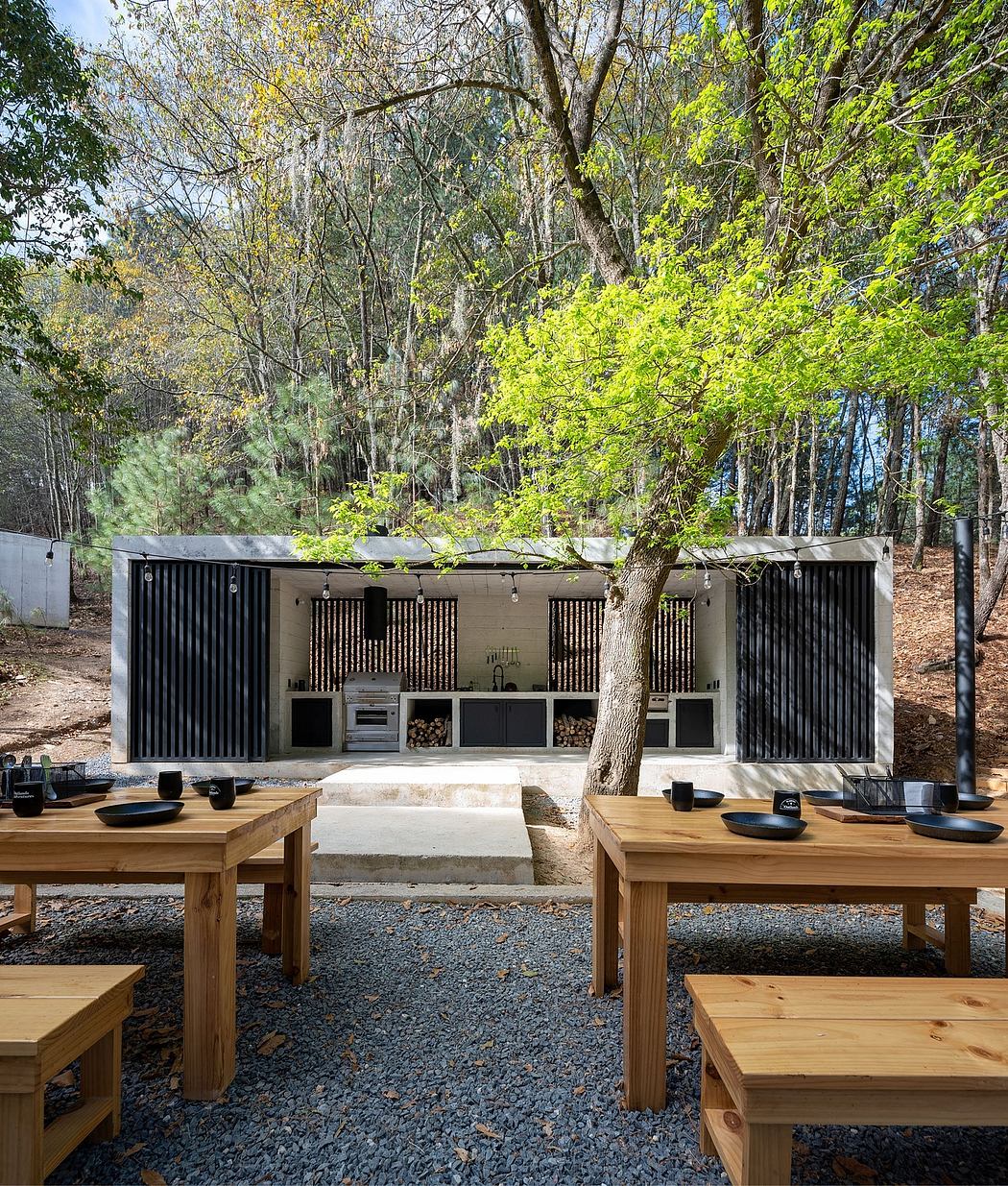 Sleek outdoor kitchen with wooden dining tables, surrounded by lush foliage.