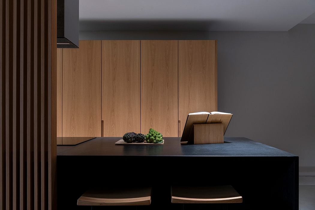 Minimalist kitchen design with sleek wooden cabinets, dark countertop, and decorative accents.