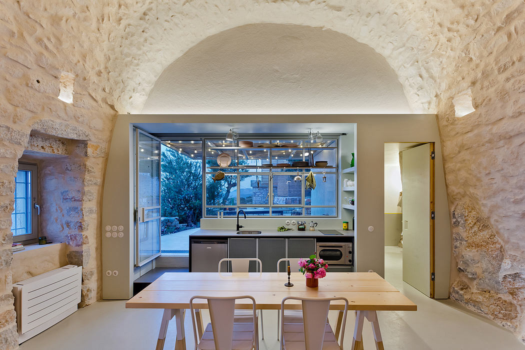 Rustic stone walls, modern kitchen, and an open space design with natural lighting.
