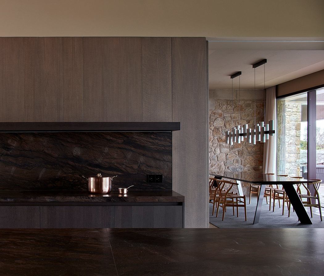 Modern kitchen with dark wood cabinets and marble backsplash.