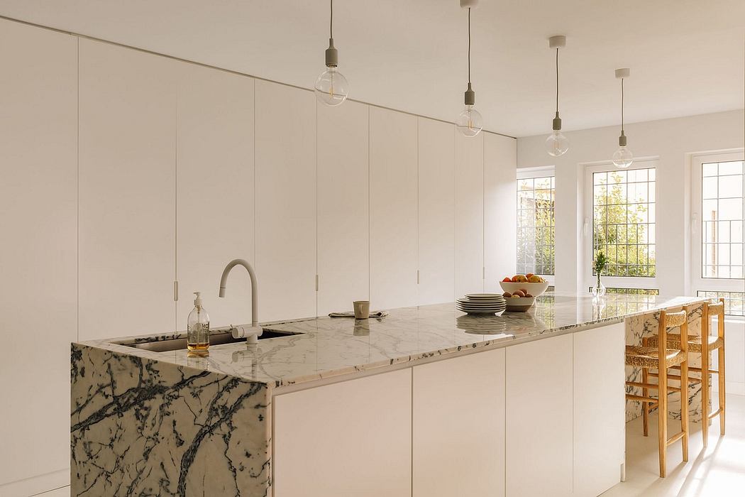 Minimalist modern kitchen with marble countertops and pendant lighting fixtures.