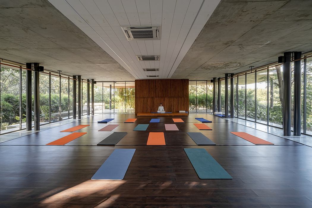Spacious yoga studio with modern architecture and colorful floor mats.