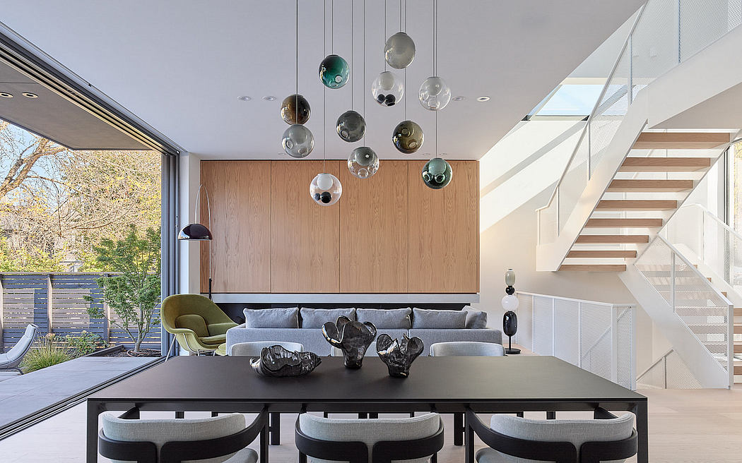 Modern living room with stylish furniture and glass bubble chandelier, adjacent to a staircase