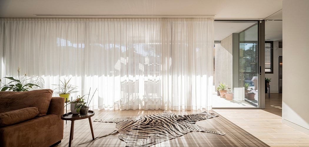 Bright living room with sheer curtains and wooden floor.