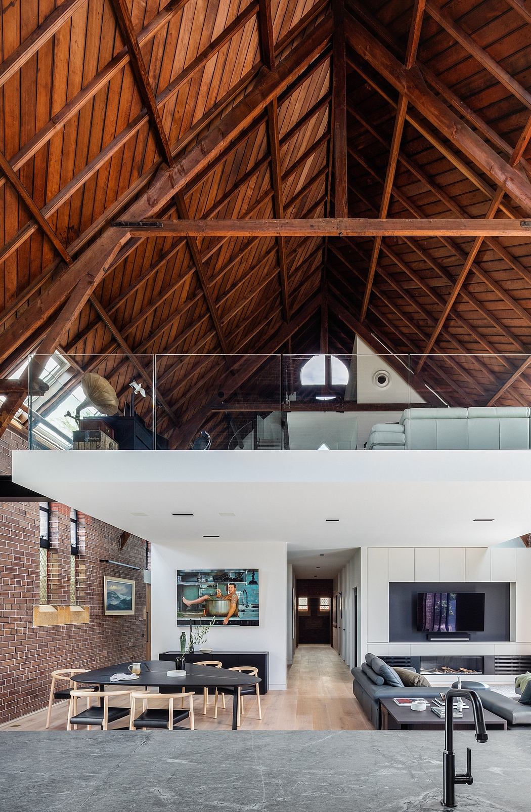 Spacious open-concept living space with exposed wooden roof trusses and modern furnishings.