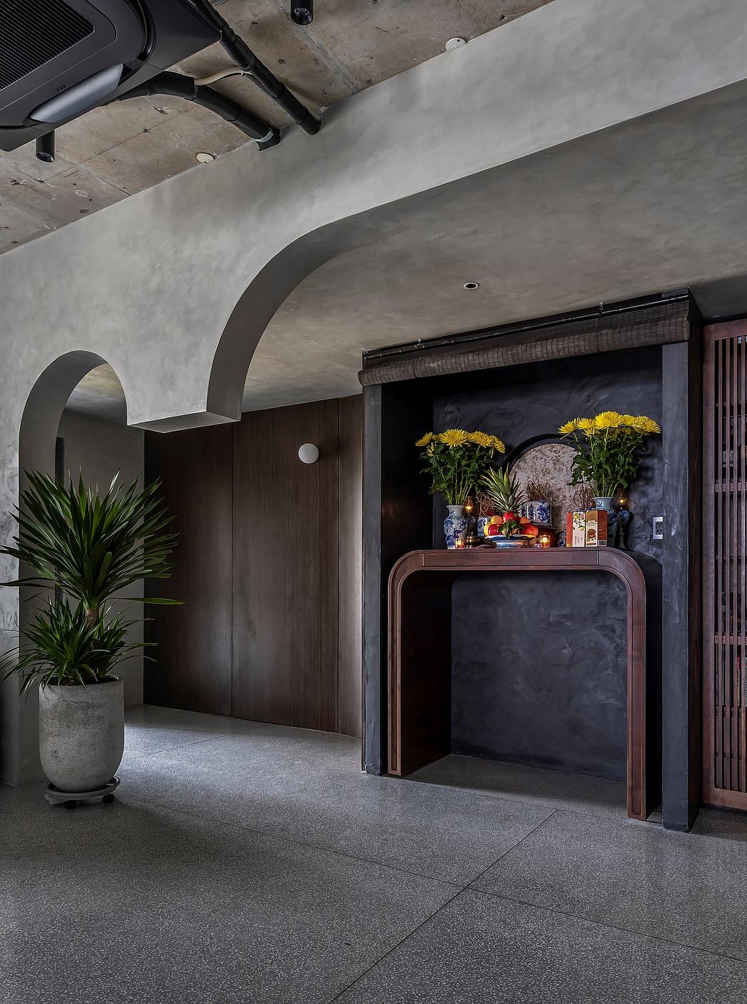Sleek, modern interior with concrete ceiling, dark wood accents, and decorative shelving.