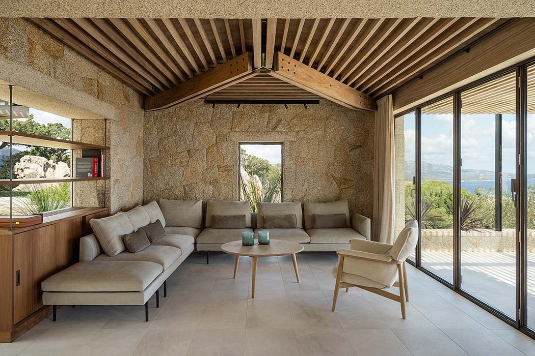Contemporary room with stone walls, wooden ceiling, and ocean view.