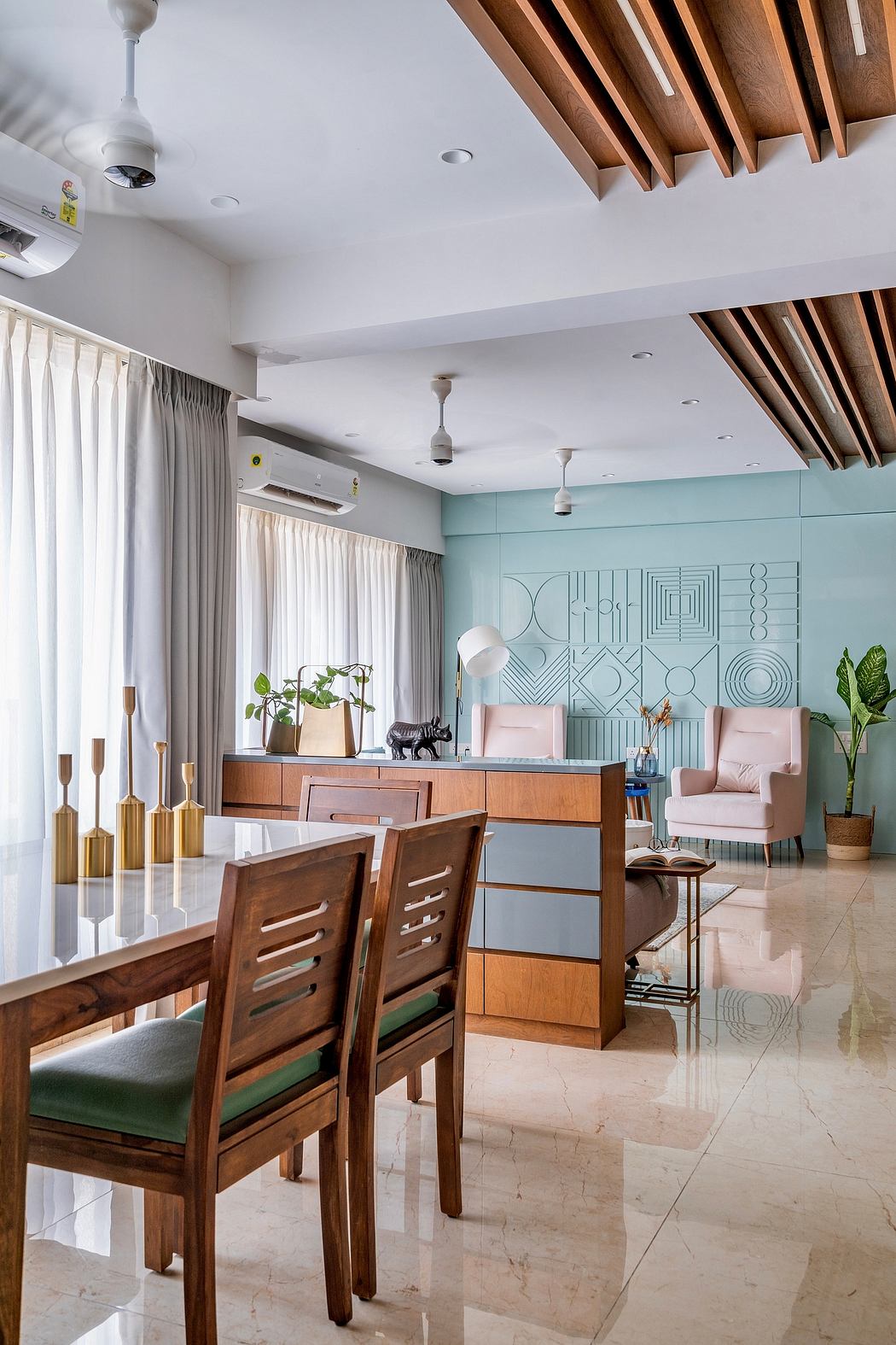 Modern dining and living room with pastel decor, wooden ceiling beams, and marble