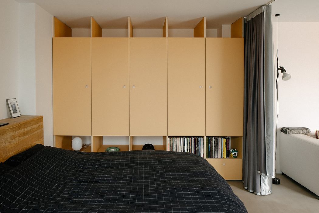 Modern bedroom with a large beige wardrobe, bed, and gray curtains.