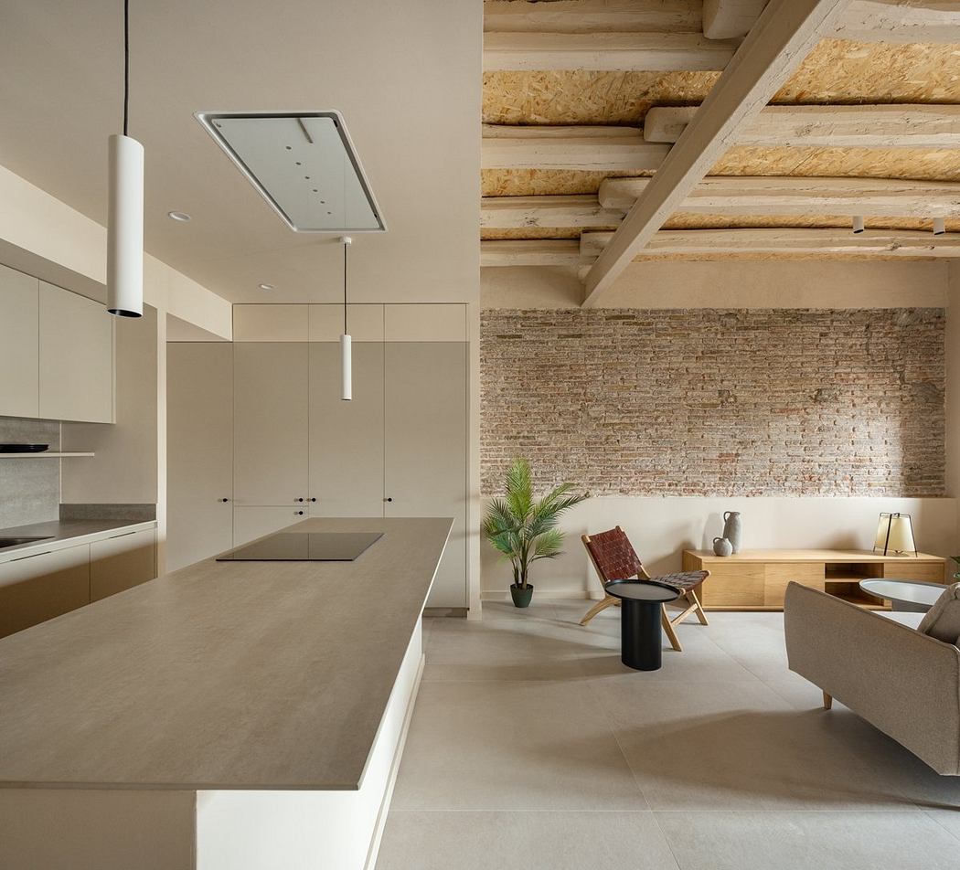 Modern open-concept kitchen with concrete countertops, brick walls, and wood ceiling beams.