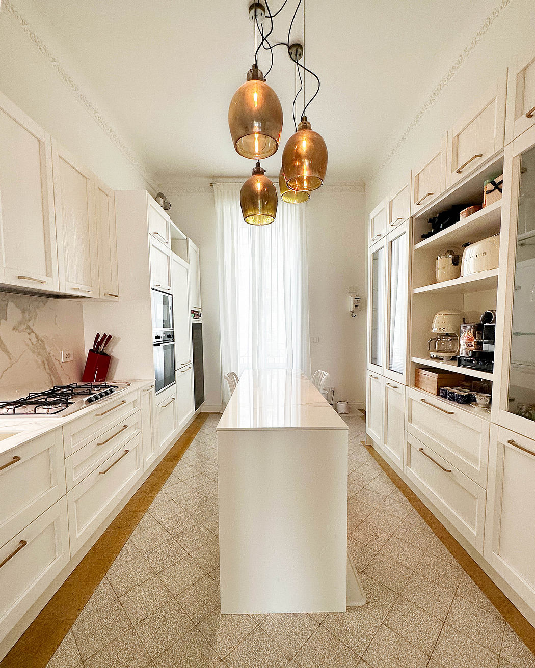 Bright white kitchen interior with copper pendant lights and sleek cabinetry.